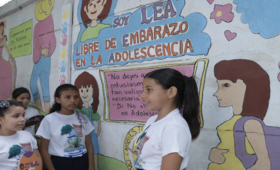 Adolescente de la Escuela Primaria Carrusel en El Viejo, Chinandega muestra el mural en el que destacan el mensaje de LEA que si